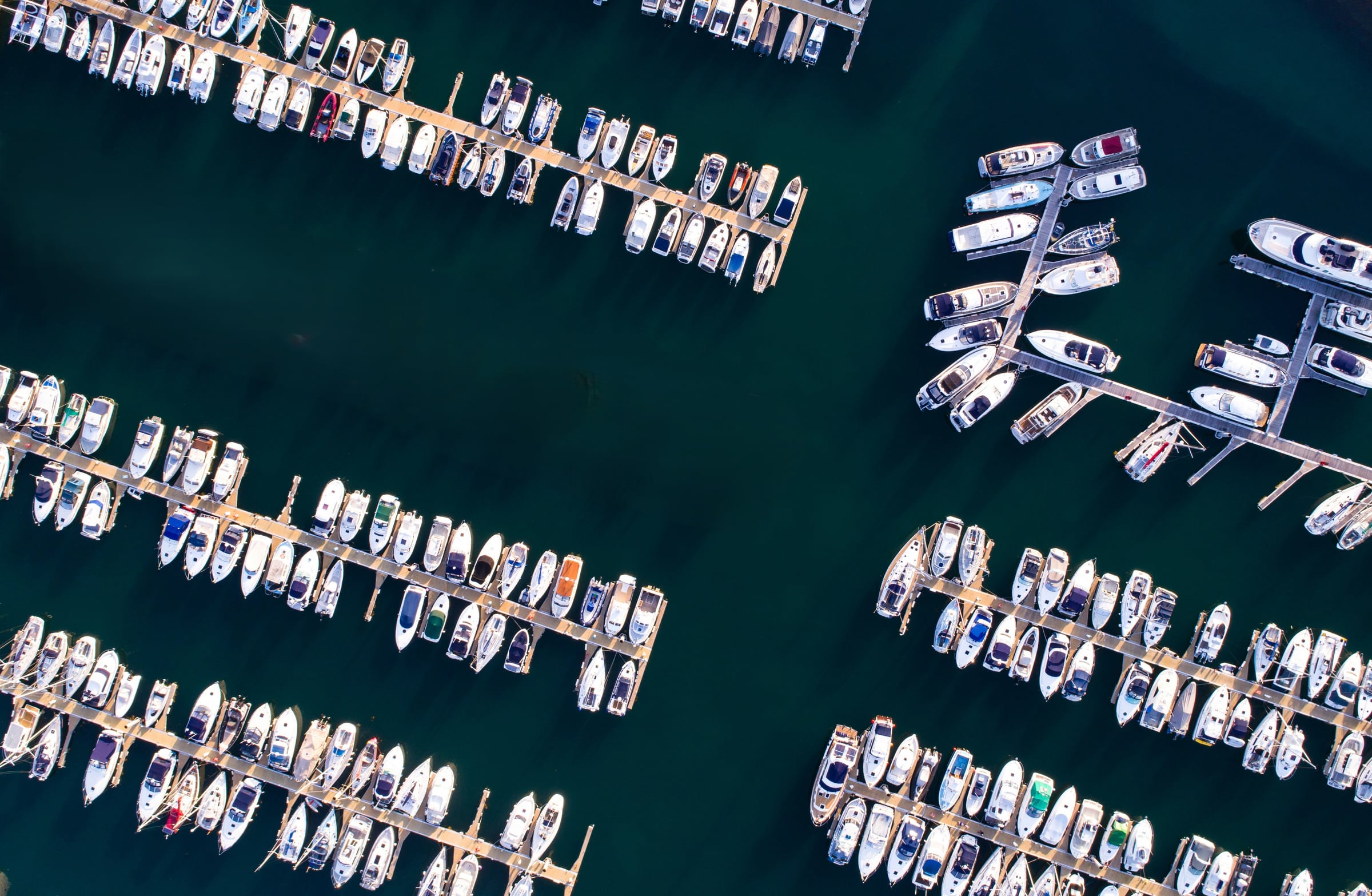 Aerial view of a Mediterranean marina with boats moored along the pontoons